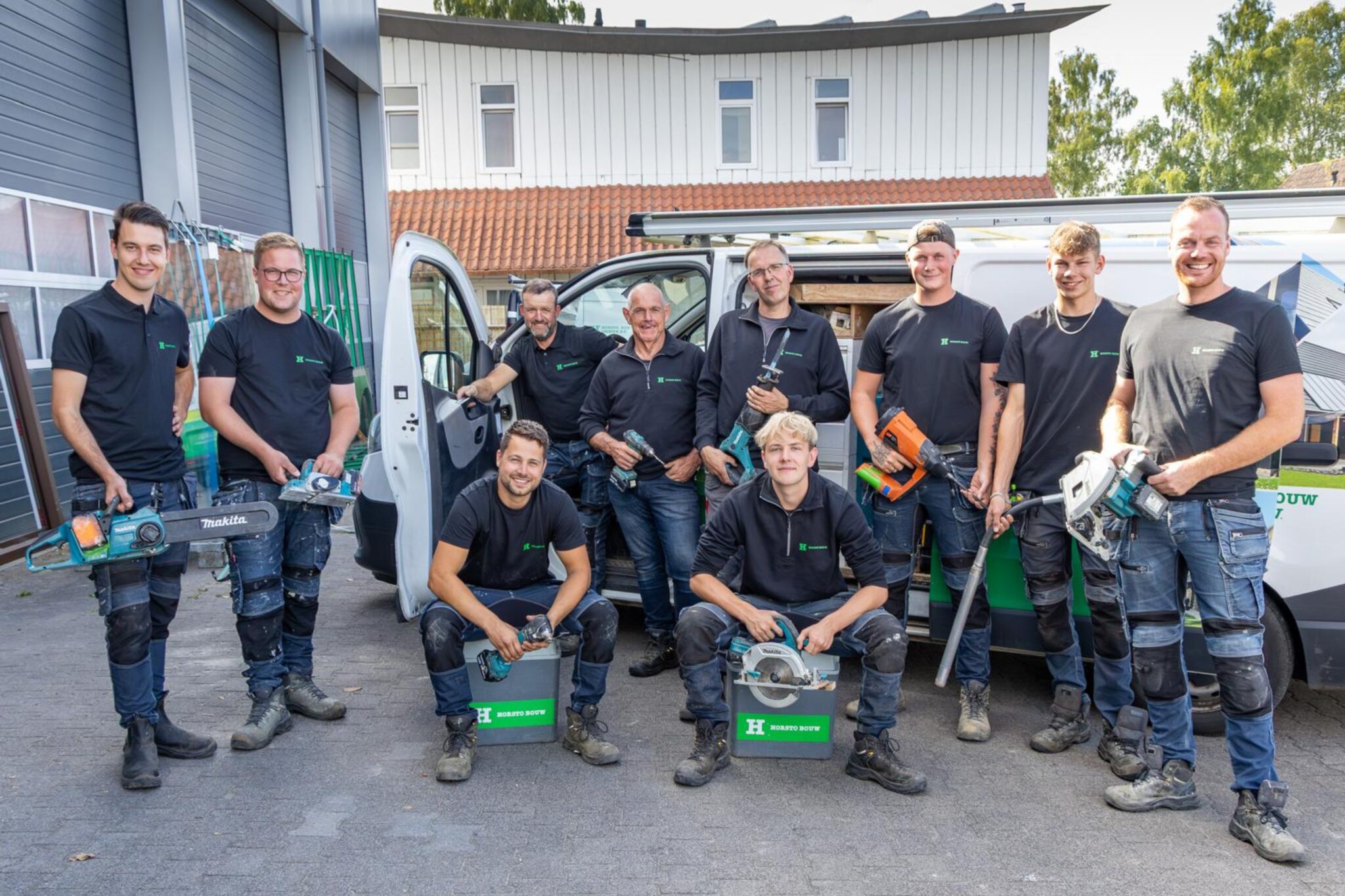 Team Horsto Bouw met allemaal gereedschap zoals een zaag, boormachine, hamers en andere timmerman- en bouwgereedschappen